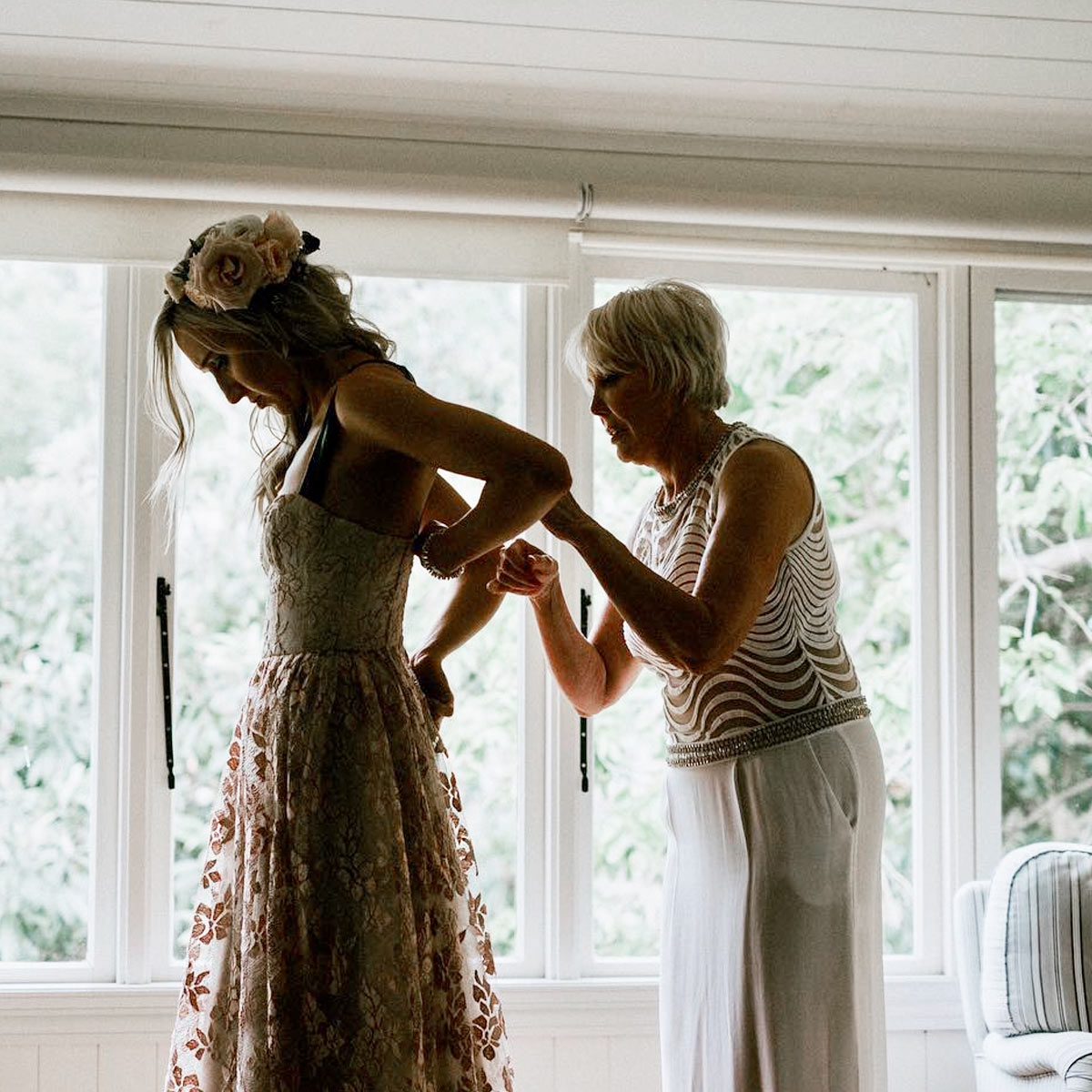 Mother of the bride fastening the bride’s dress in the Bangalow Suite at Bangalow Guesthouse