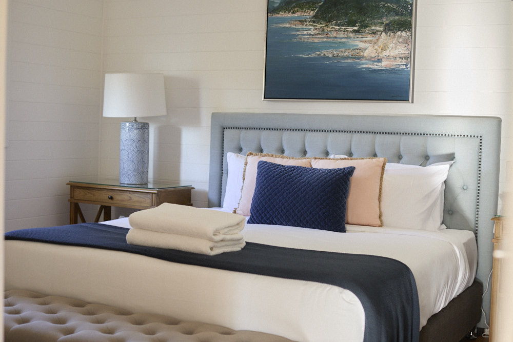 Miller Apartment king bed with original artwork and heritage-style decor at Bangalow Guesthouse near Byron Bay hinterland