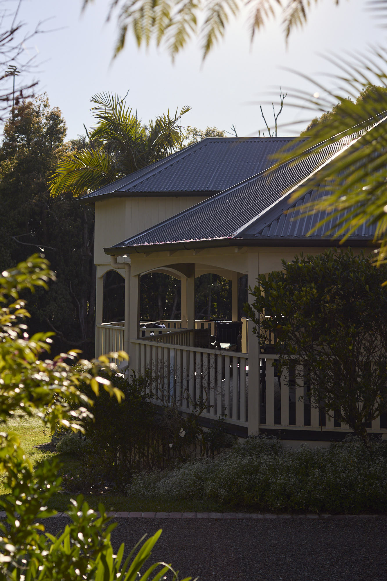 Cool evening view of the softly lit Bangalow Guesthouse seen from Dr Lentaigne’s Cottage in the Byron Bay hinterland