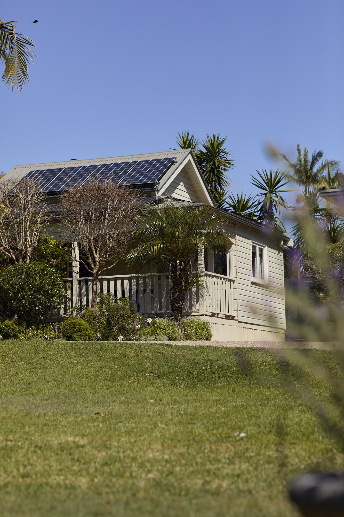 Exterior of Bangalow Guesthouse with rooftop solar panels surrounded by heritage gardens in the Byron Bay hinterland